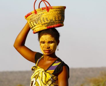 Portrait of Malagasy woman with traditional mask on the face, Madagascar